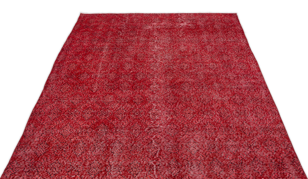 Distressed crimson red rug with a repeating black geometric floral pattern on a white background.