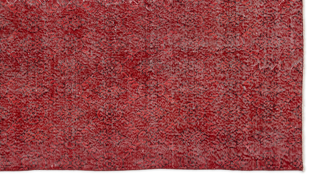 Deep red rug with a subtle, distressed geometric diamond pattern and a white fringe edge.