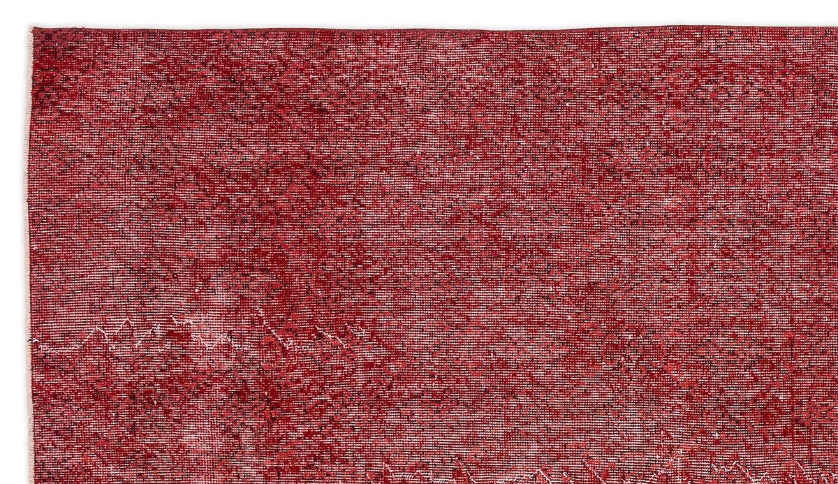 Deep red vintage-style rug with a faint, distressed geometric medallion pattern on a white background.