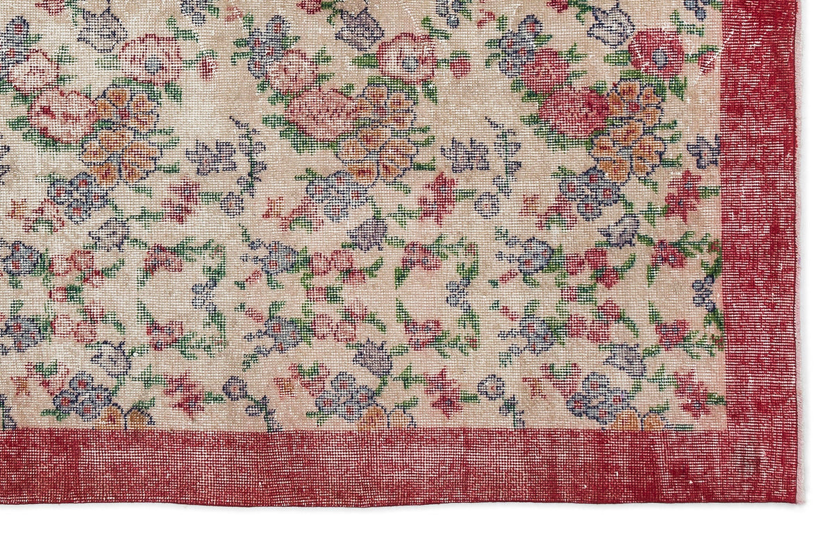 Beige rug with a multi-colored floral pattern in red, blue, and green, featuring a solid red border.