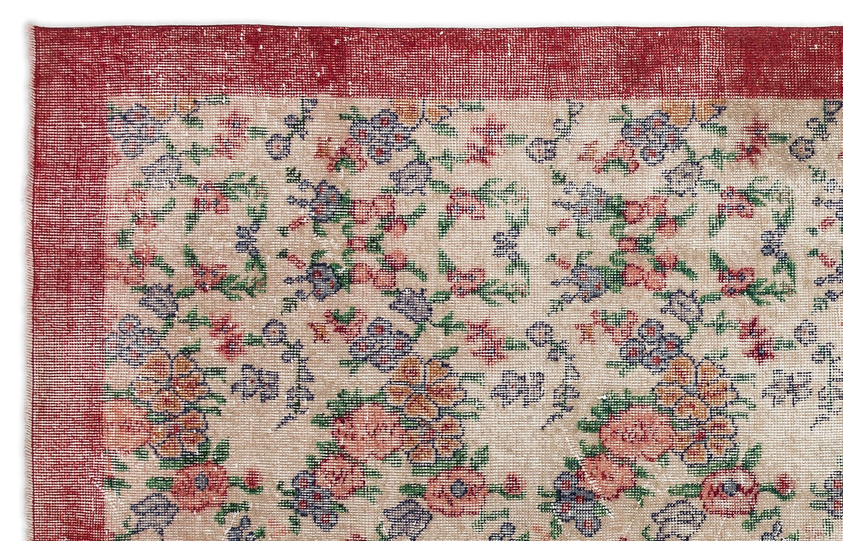 Beige rug with a distressed floral pattern in red, blue, and green, featuring a wide red border.