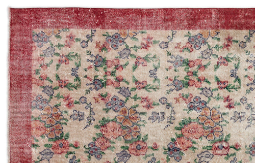 Load image 1 in gallery view. Beige rug with a distressed floral pattern in red, blue, and green, featuring a wide red border.