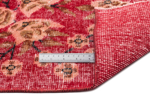 Load image 1 in gallery view. Red and peach floral patterned rug with a folded corner revealing the woven backing and a metal ruler for scale.