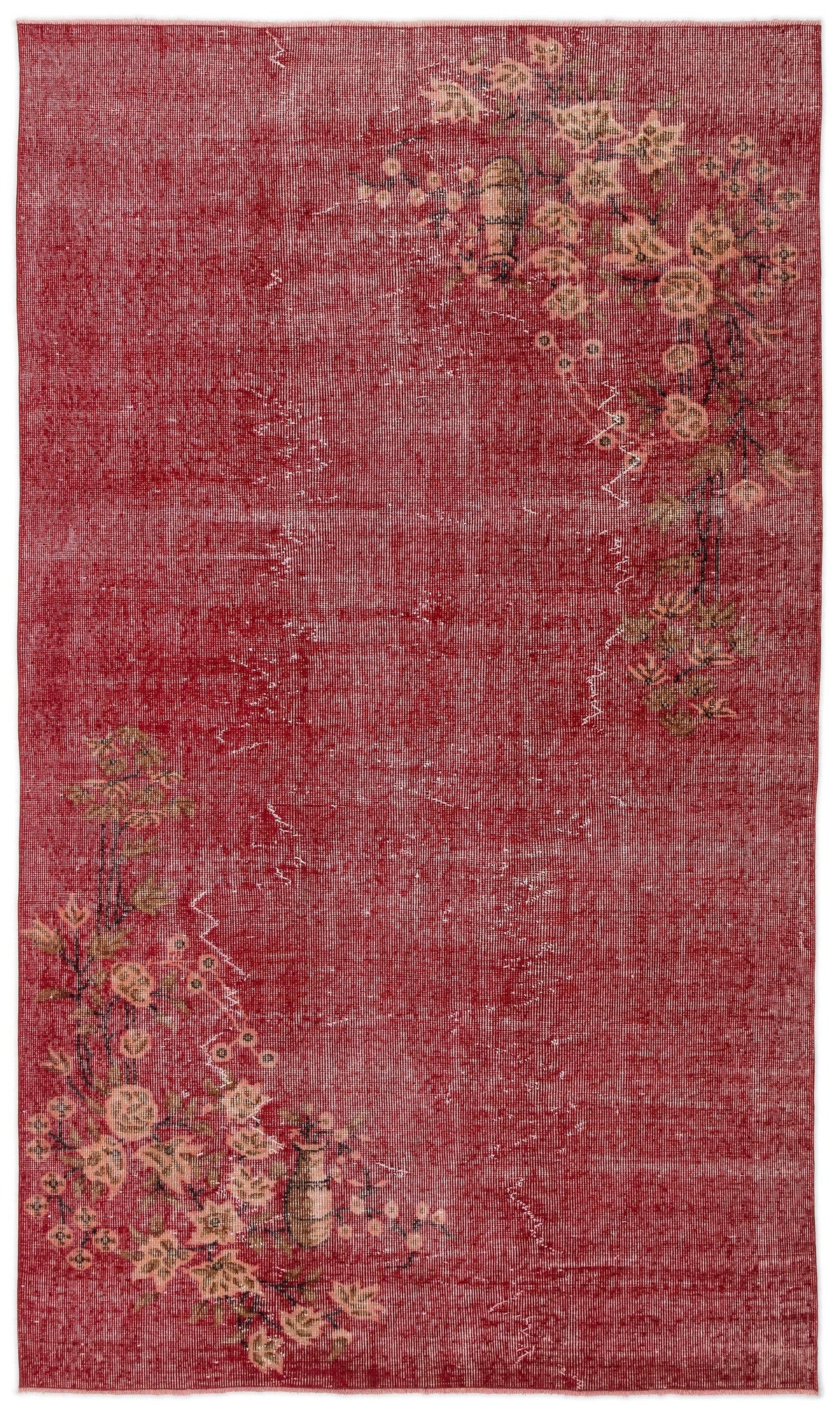 Distressed red rug with asymmetrical floral branch motifs in muted beige and green tones.