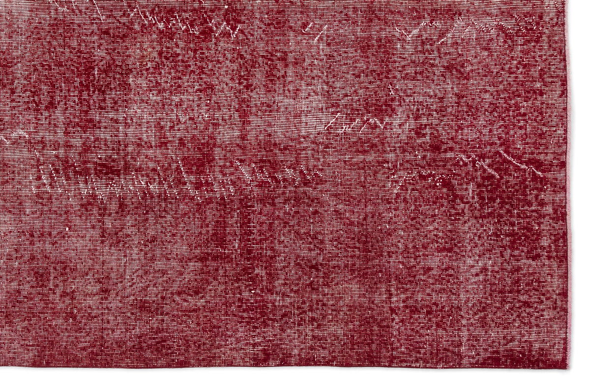 Deep red rug with a distressed, weathered texture and white woven details.
