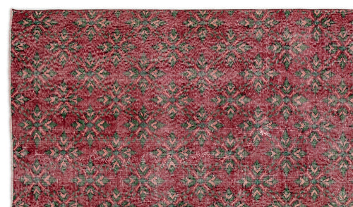 Load image 1 in gallery view. Deep red rug with a repeating green and light pink geometric floral pattern and a distressed texture.