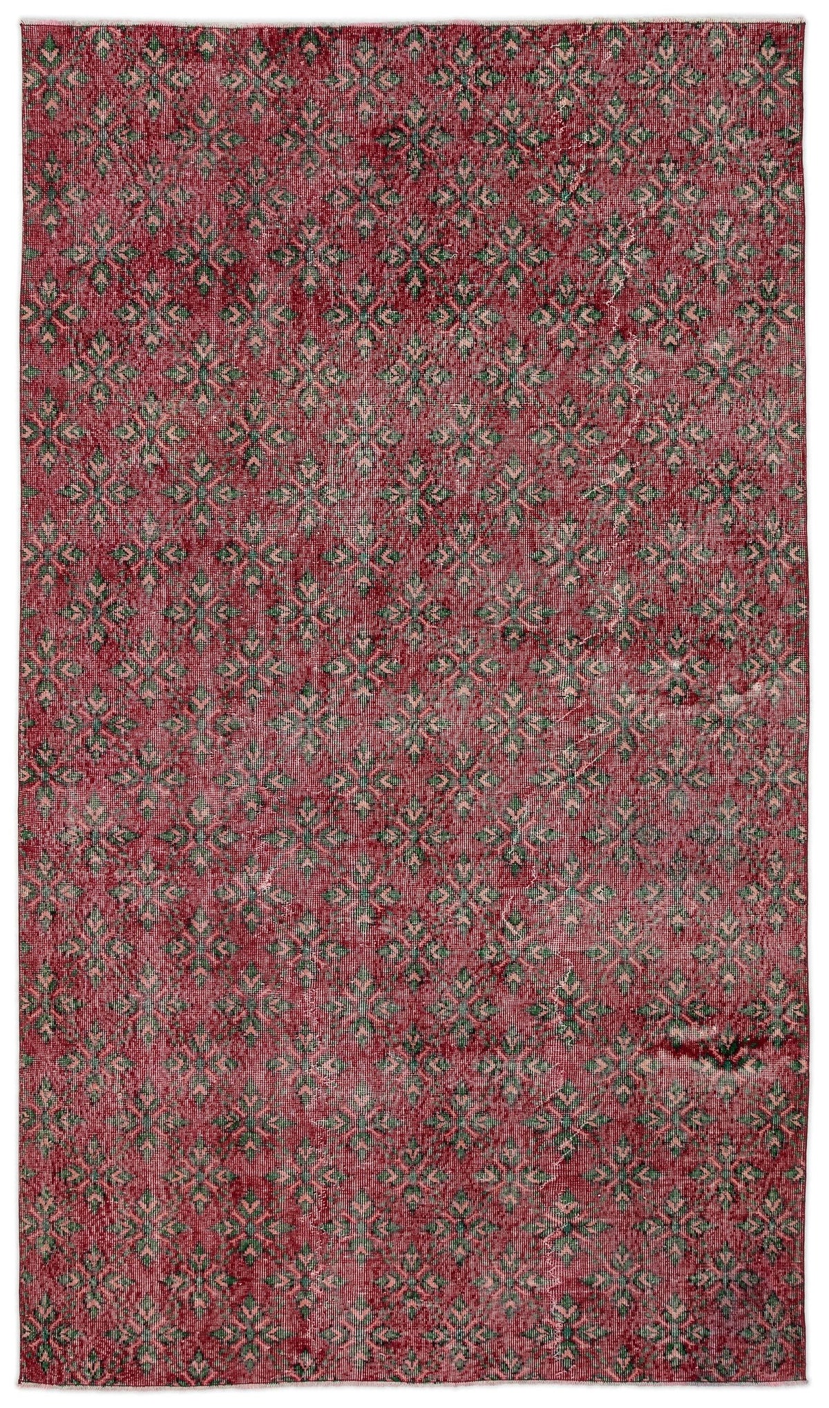 Red and green distressed rug with a repeating geometric floral pattern.
