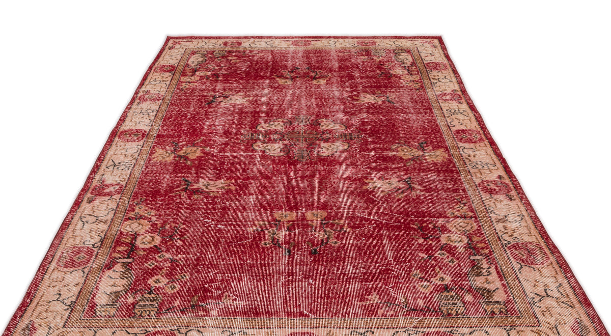 Distressed red and beige traditional rug with a central floral medallion and ornate border pattern.