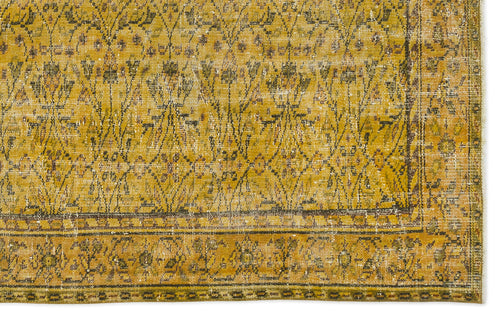 Load image 1 in gallery view. Mustard yellow vintage-style rug with a distressed diamond lattice pattern and a decorative floral border.