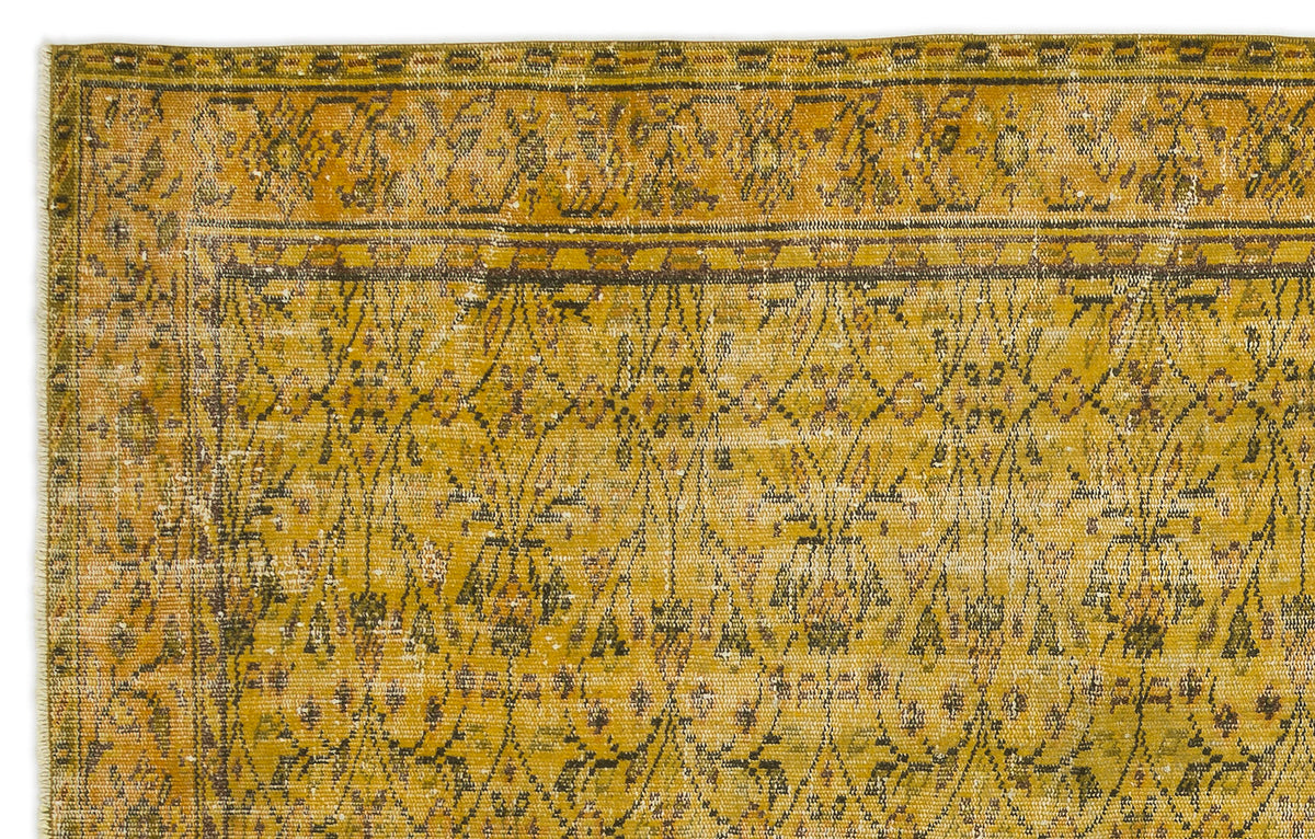 Mustard yellow vintage-style rug with a dark brown geometric lattice and floral motif, featuring a distressed finish.
