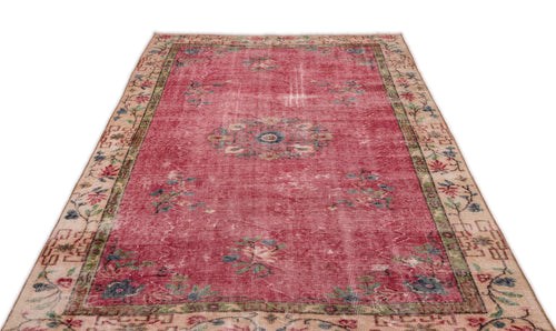 Load image 1 in gallery view. Distressed red vintage rug with a central floral medallion and a beige border featuring botanical motifs.