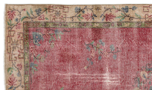 Load image 1 in gallery view. Distressed red rug with a beige floral border and geometric accents, featuring a faded, vintage-style texture.