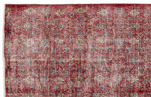 Load image 1 in gallery view. Distressed red rug with a faded floral medallion pattern in cream, blue, and yellow accents.