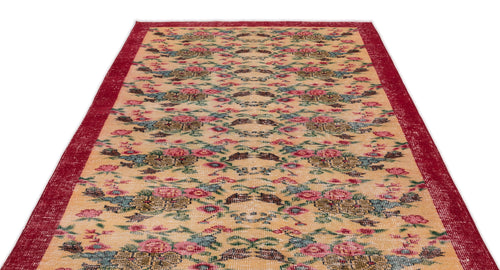 Load image 1 in gallery view. Beige rug with a distressed floral pattern in red, green, and brown, featuring a wide red border.