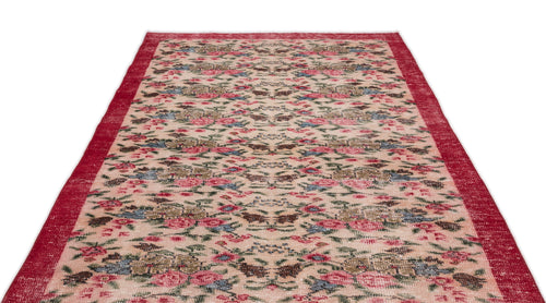 Load image 1 in gallery view. Beige vintage-style rug with a red border and a distressed floral pattern in red, blue, and green.