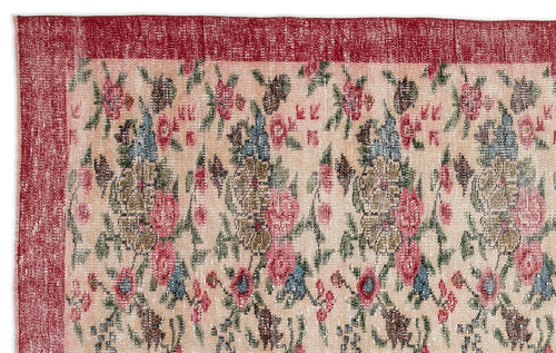 Load image 1 in gallery view. Distressed beige rug with a red border and a repeating floral pattern in shades of pink, blue, and green.