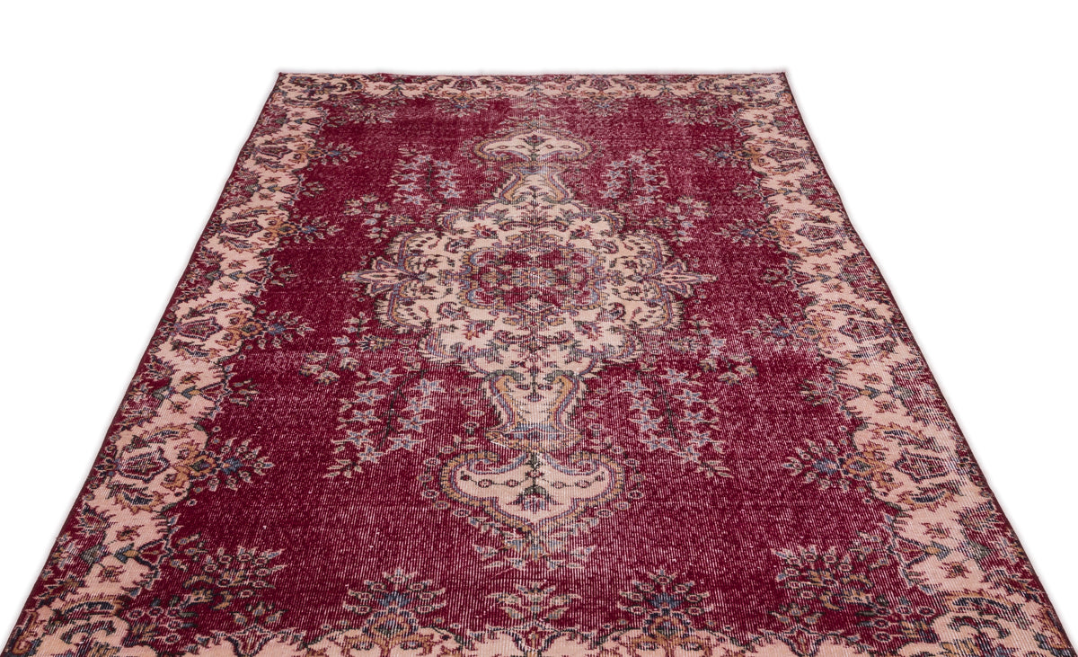 Deep red vintage-style rug with a central cream floral medallion and ornate border on a white background.
