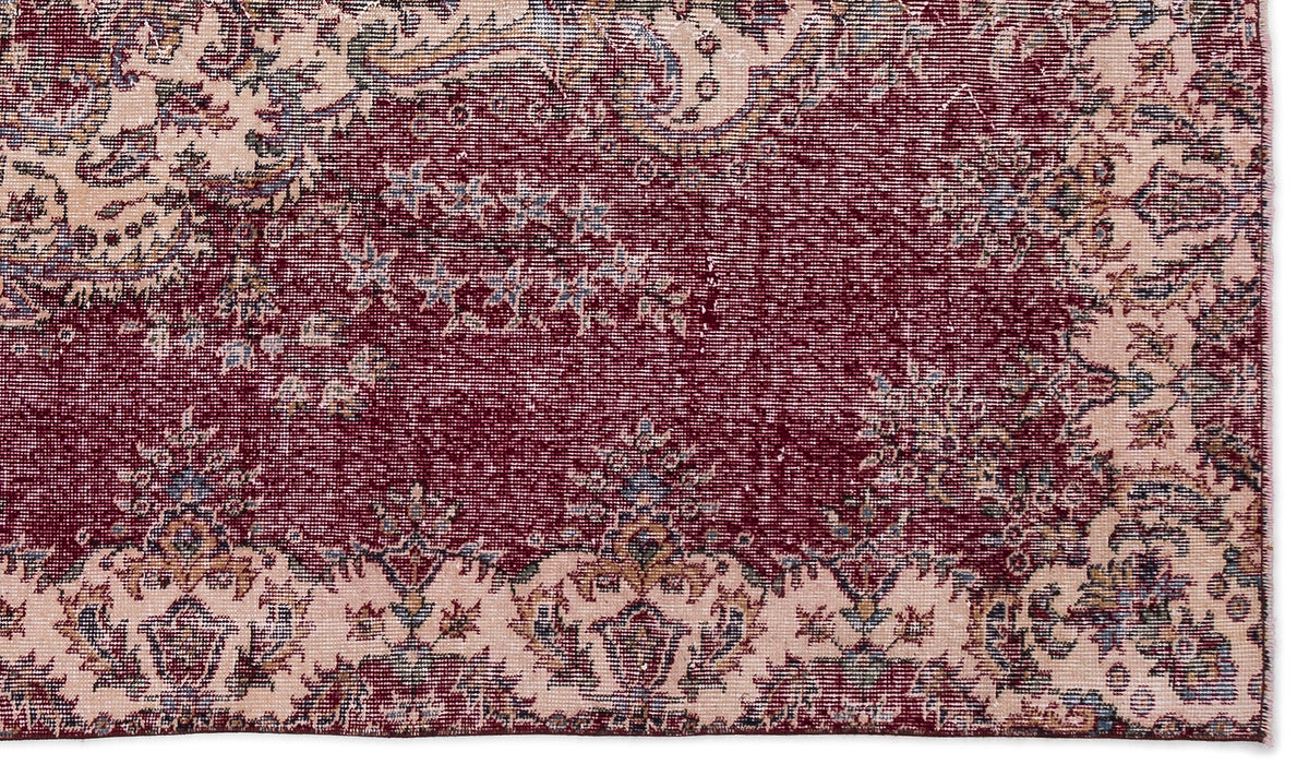Deep red and cream traditional rug with a distressed floral medallion pattern and intricate border details.