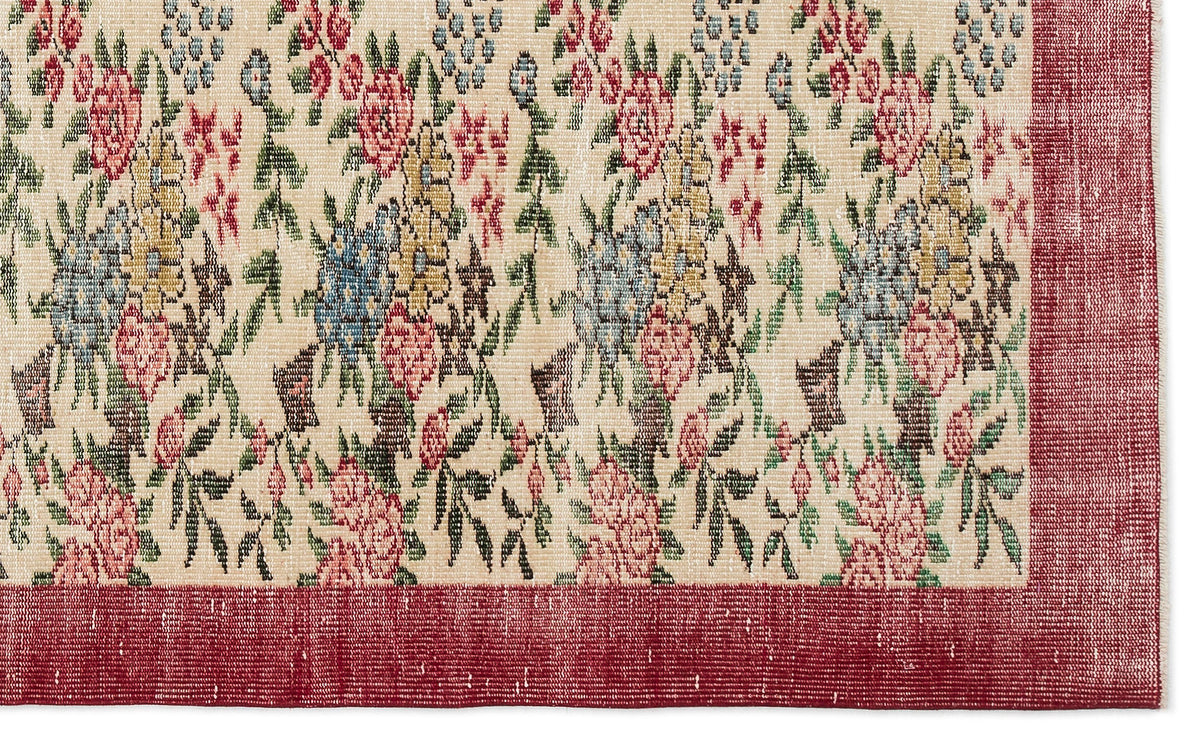 Cream rug with a multi-colored floral pattern and a solid red border.