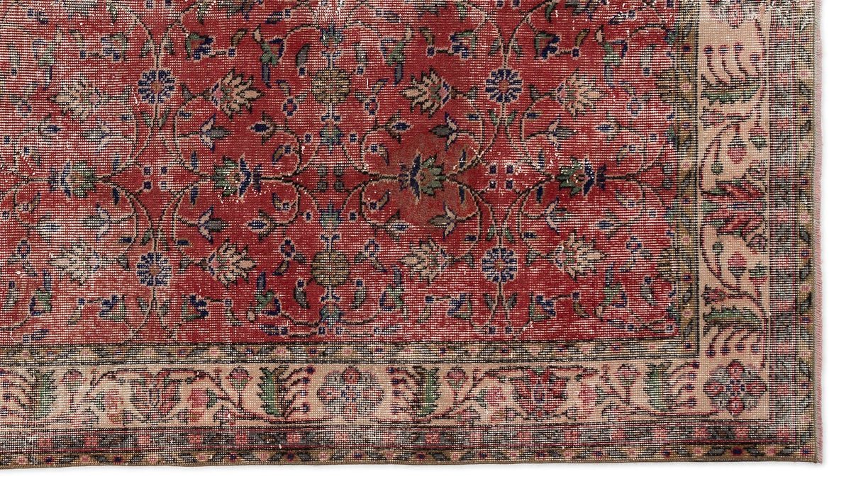 Red traditional rug with a floral vine pattern and a beige decorative border.