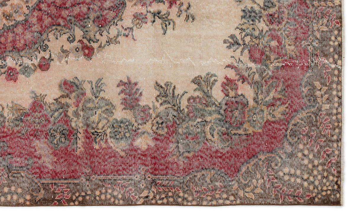 Distressed beige rug with a red and dark grey floral medallion pattern and a detailed border.