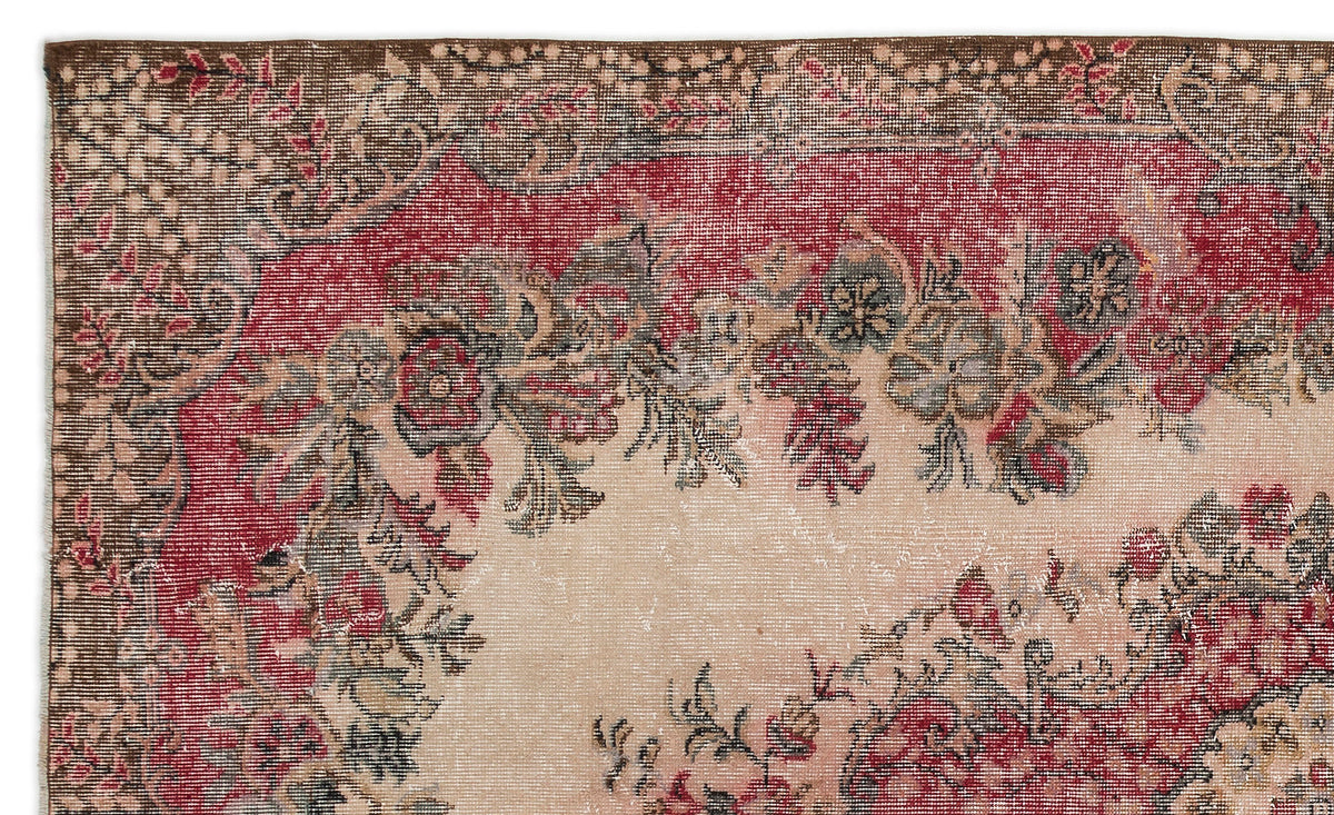 Distressed vintage-style rug with a red and beige floral medallion pattern and a dark brown border.