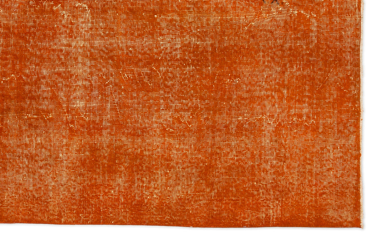 Burnt orange rug with a distressed, weathered texture and visible horizontal weave.