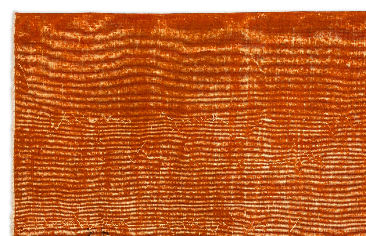 Burnt orange rug with a distressed, weathered texture and visible horizontal weave pattern.