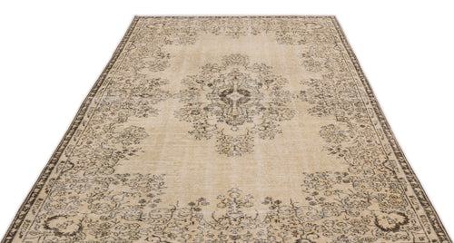 Load image 1 in gallery view. The Preutata Vintage Medallion Rug (5'4" x 8'11") is a rectangular beige area rug with an ornate floral medallion pattern in dark brown, a decorative border, and a slightly faded vintage look, inspired by classic Anatolian hand-woven designs.