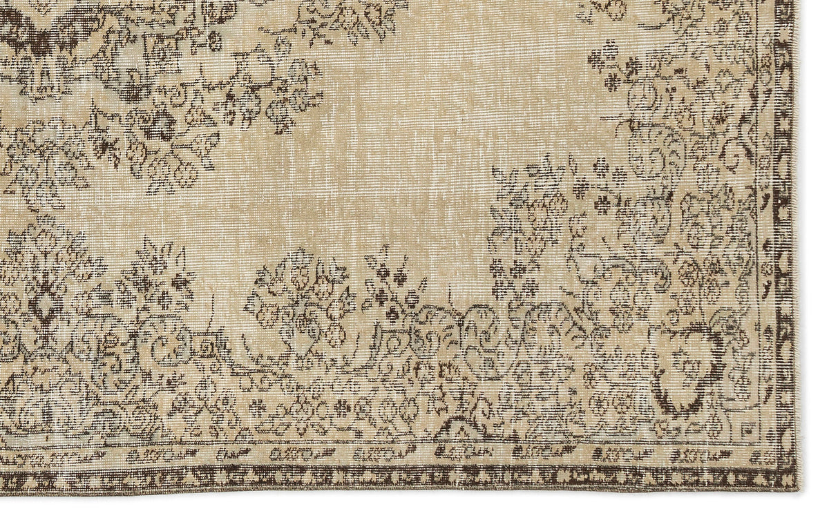 A section of the Preutata Vintage Medallion Rug (5'4 x 8'11) in beige, showcasing an ornate floral and vine pattern in brown and gray tones with a decorative border.