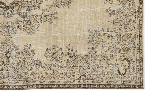 Load image 1 in gallery view. A section of the Preutata Vintage Medallion Rug (5'4 x 8'11) in beige, showcasing an ornate floral and vine pattern in brown and gray tones with a decorative border.