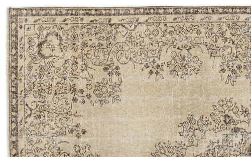 Load image 1 in gallery view. A close-up of the Preutata - Vintage Medallion Rug (5'4 x 8'11) shows a beige, hand-woven Anatolian design with intricate brown floral and vine borders. The lighter central area with minimal detailing highlights its vintage charm.