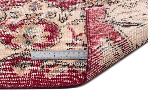 Load image 1 in gallery view. Red and cream traditional medallion rug with a folded corner and a stainless steel ruler for scale.