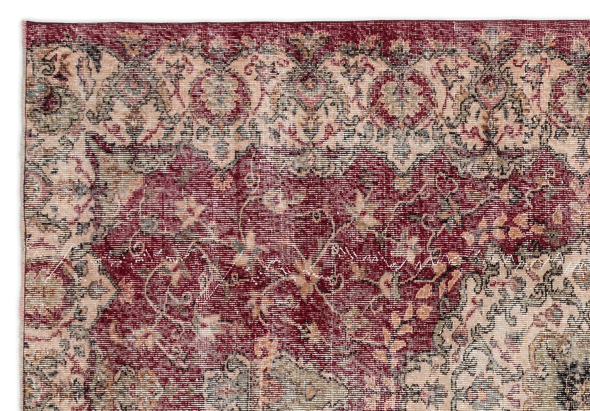 Deep red and beige traditional rug with a distressed, intricate floral medallion pattern.