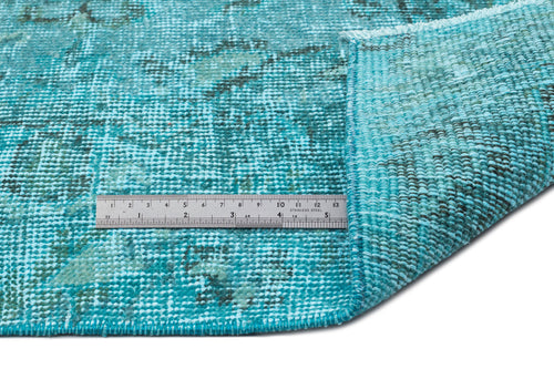 Load image 1 in gallery view. Turquoise and black distressed vintage-style rug with a folded corner and a metal ruler for scale on a white background.