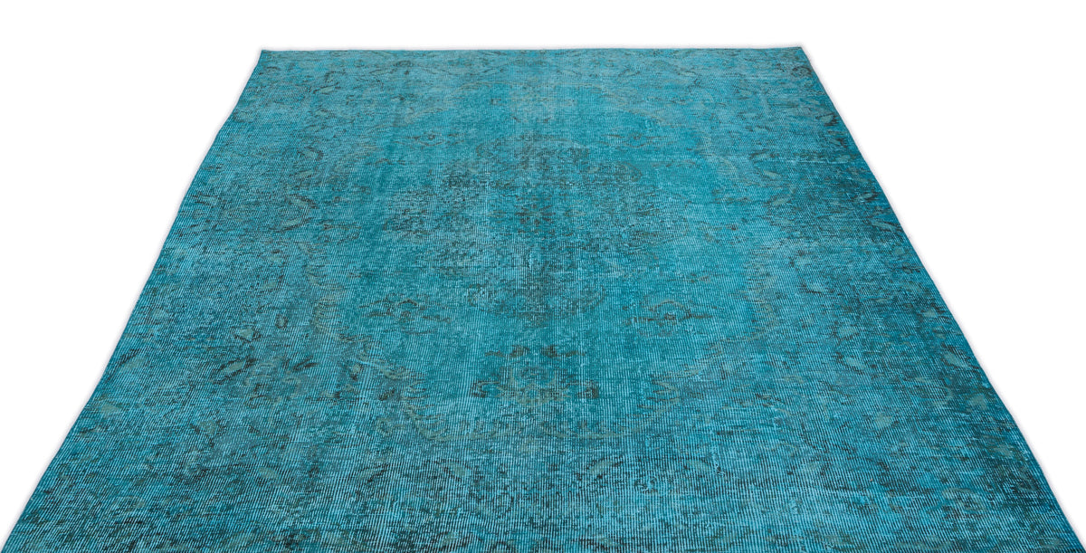 Teal distressed area rug with a faded traditional medallion pattern on a white background.