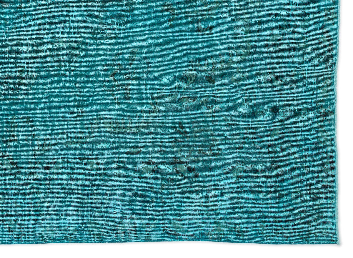 Teal rug with a distressed, faded traditional pattern and visible woven texture on a white background.