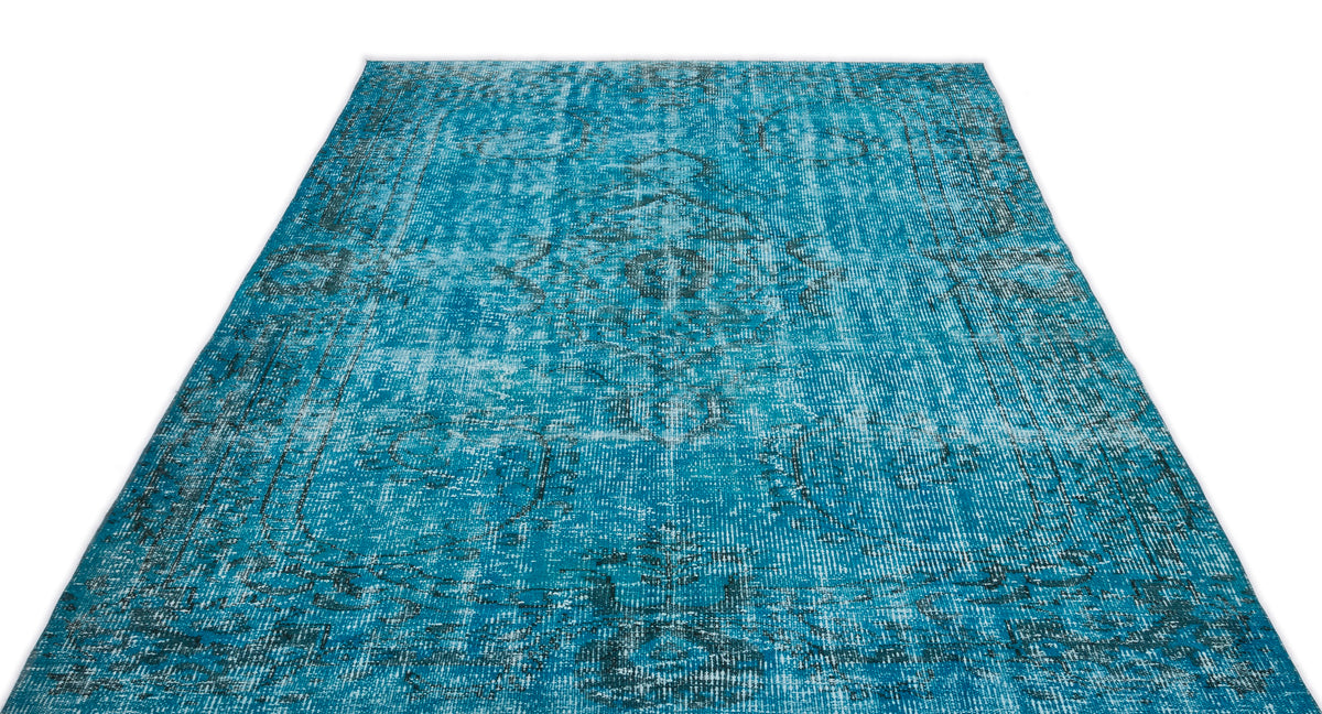 Bright turquoise distressed area rug with a faded traditional medallion pattern on a white background.
