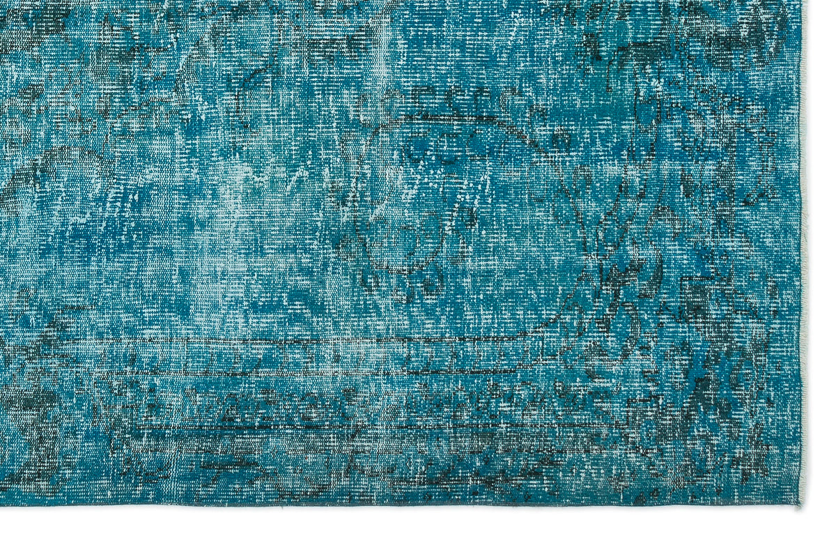 Teal and black distressed rug with a faded traditional medallion pattern.