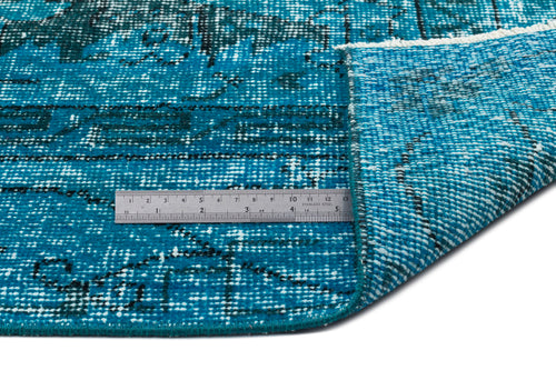 Load image 1 in gallery view. Teal and black distressed patterned rug with a folded corner, shown with a metal ruler for scale on a white background.