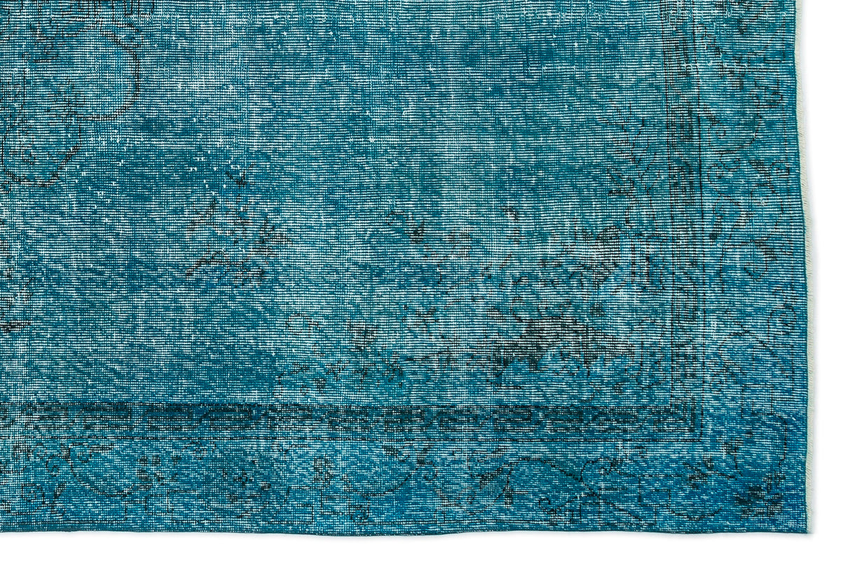 Teal distressed rug with a faded black traditional floral border and medallion pattern.