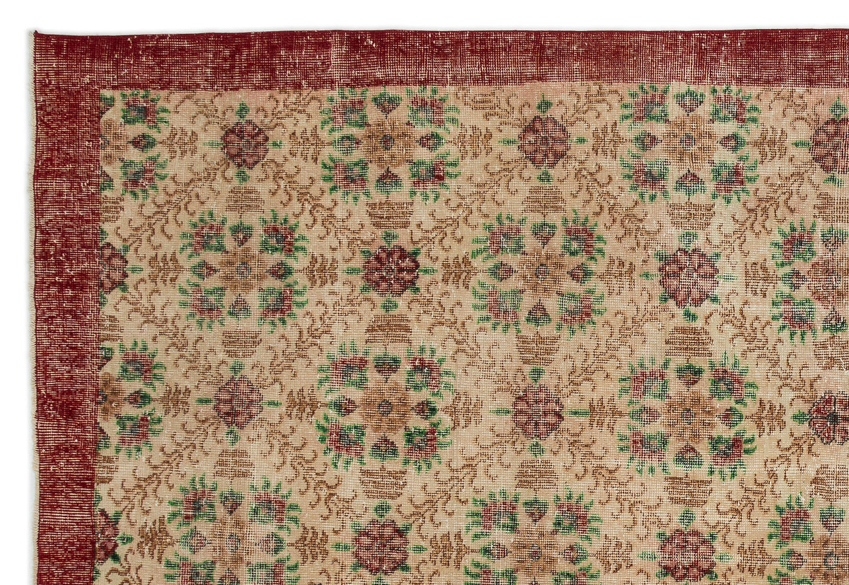 Beige rug with a red border and repeating floral medallion pattern in red and green on a white background.