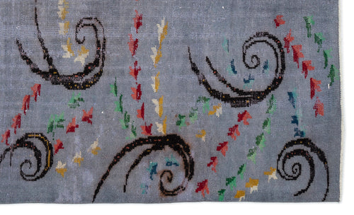 Load image 1 in gallery view. Grey rug with black spiral motifs and scattered small red, green, and yellow abstract shapes.