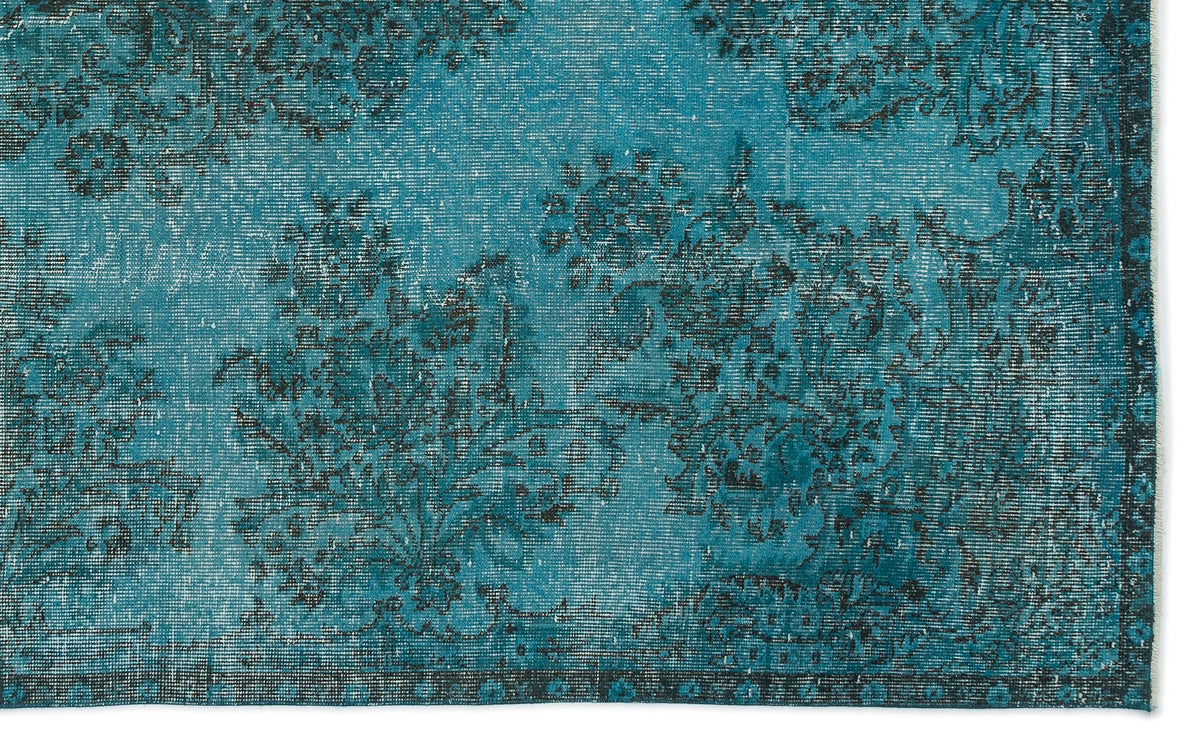 Teal and black distressed rug with an ornate floral medallion pattern and a dark decorative border.