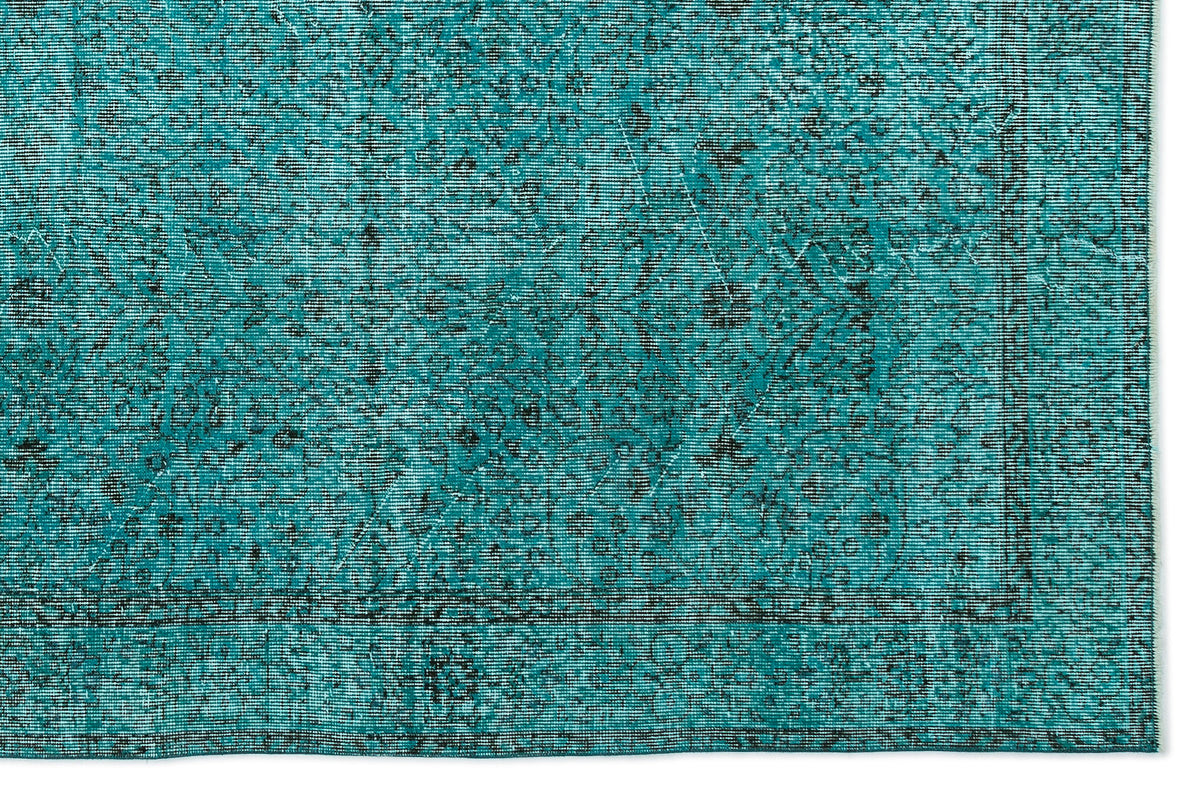Teal and black distressed rug with a traditional medallion pattern and a bordered edge.