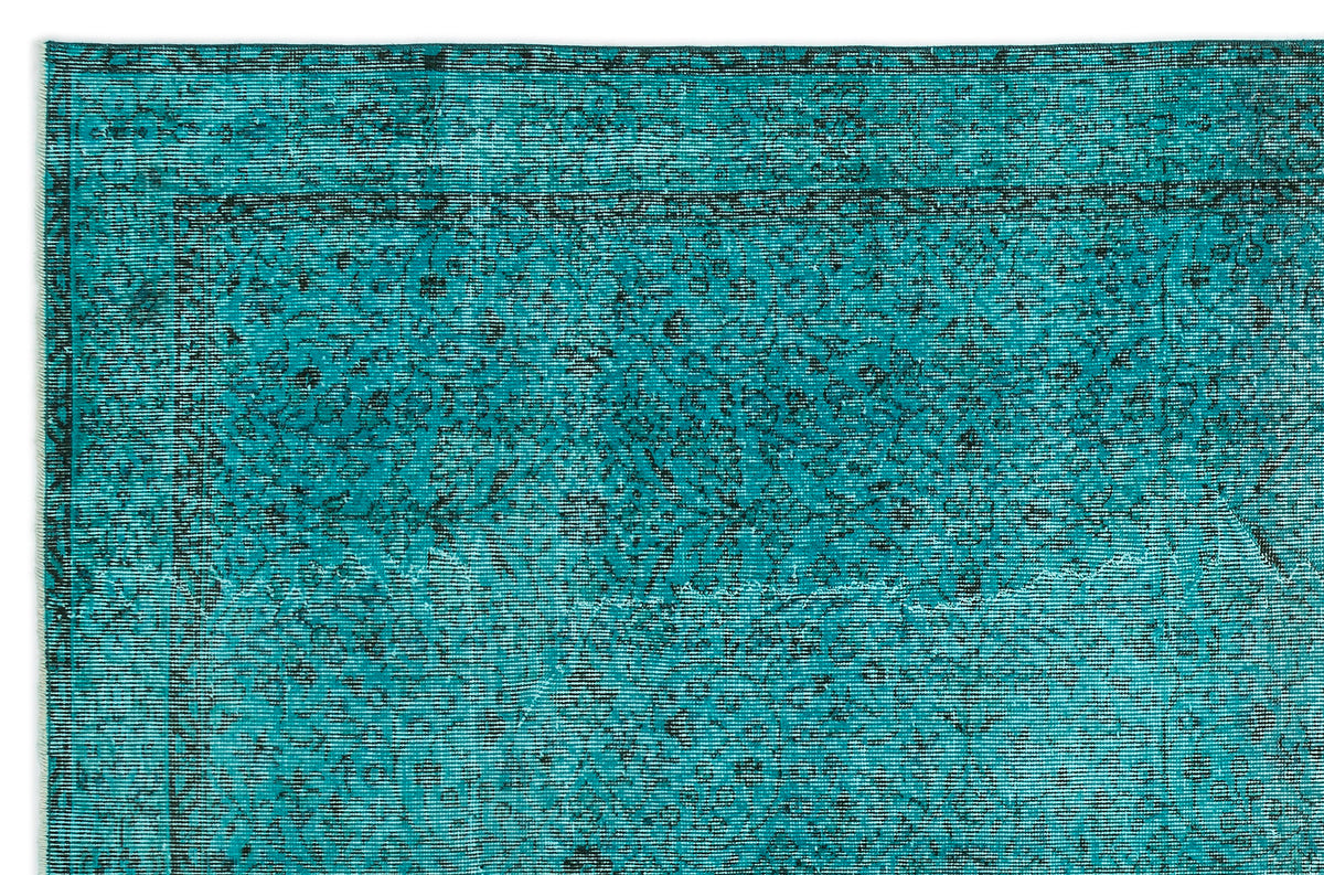 Teal and black rug with a distressed traditional floral medallion pattern and a bordered edge.