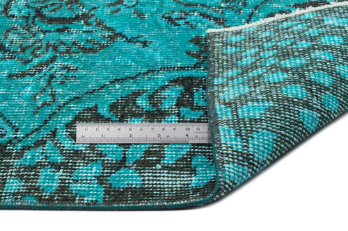 Load image 1 in gallery view. Teal and black distressed floral rug with a folded corner revealing the woven backing and a metal ruler for scale.