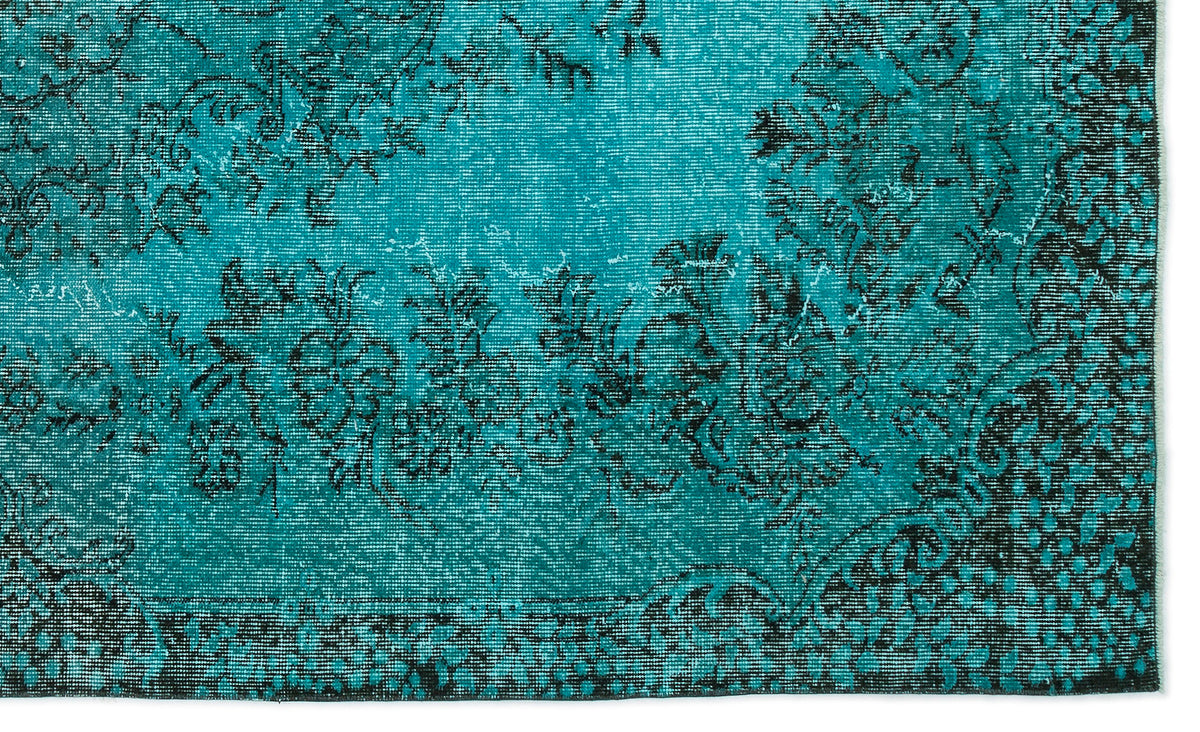 Teal and black distressed rug with a traditional floral medallion pattern.