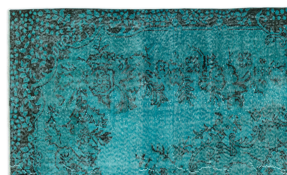 Teal and black rug with a distressed, traditional floral medallion pattern.