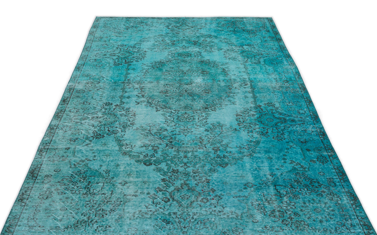 Turquoise distressed rug with a dark grey traditional medallion pattern on a white background.